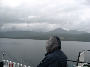 Girl with raincoat on a ferry leaving the island