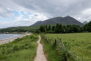 Path beside a beach and mountains in the background