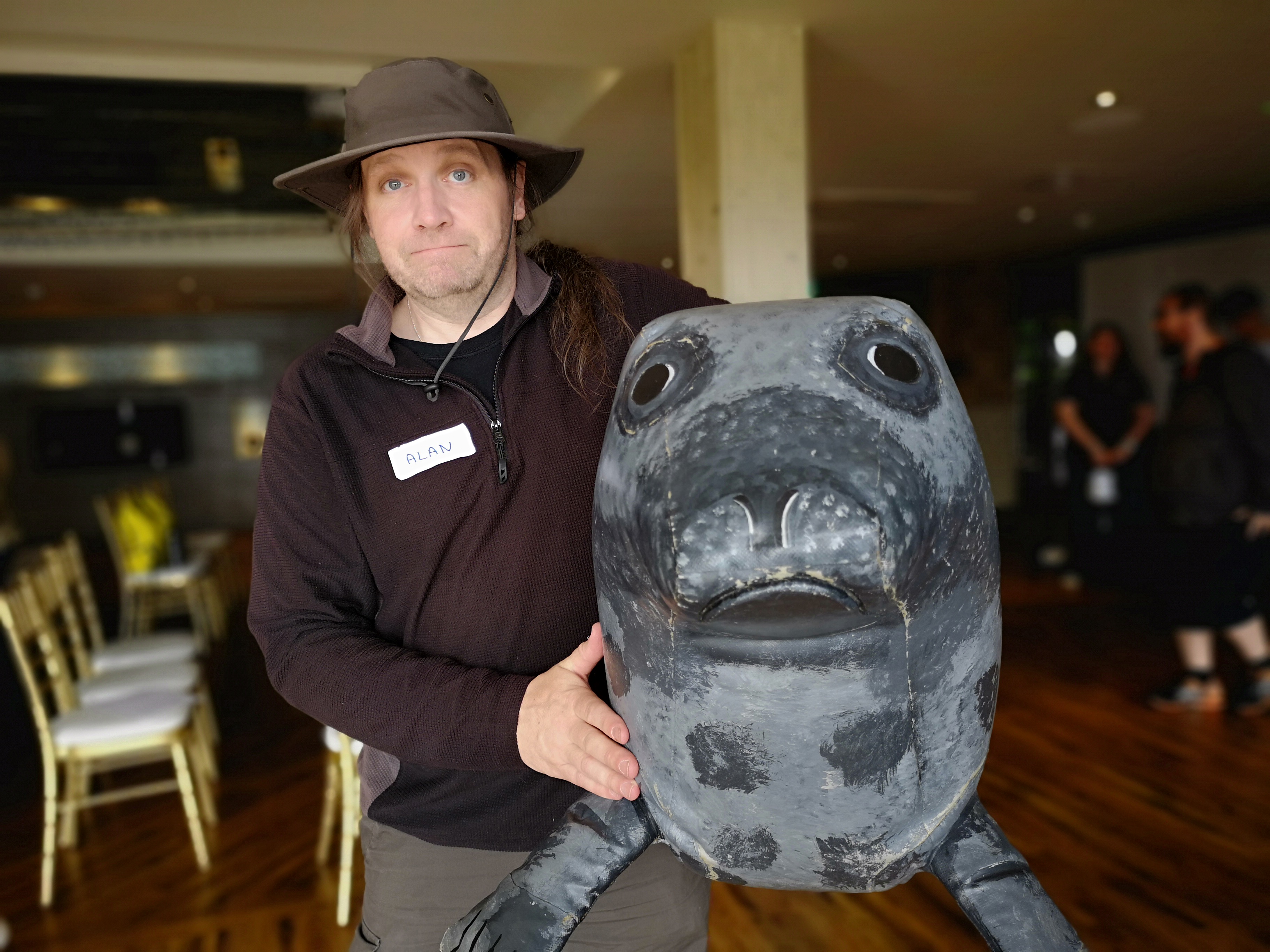 A person holding an inflatable seal, both looking sad