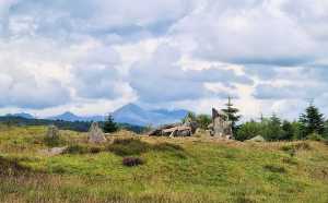 Large slabs of stone on a hill which are the remains of a neolithic tomb