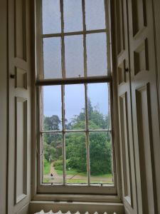 Window with a view looking out at trees and paths