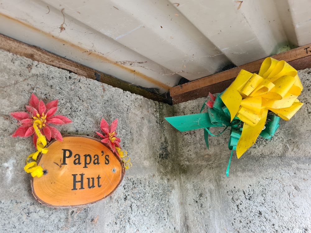 Wooden plaque saying "Papa's Hut"