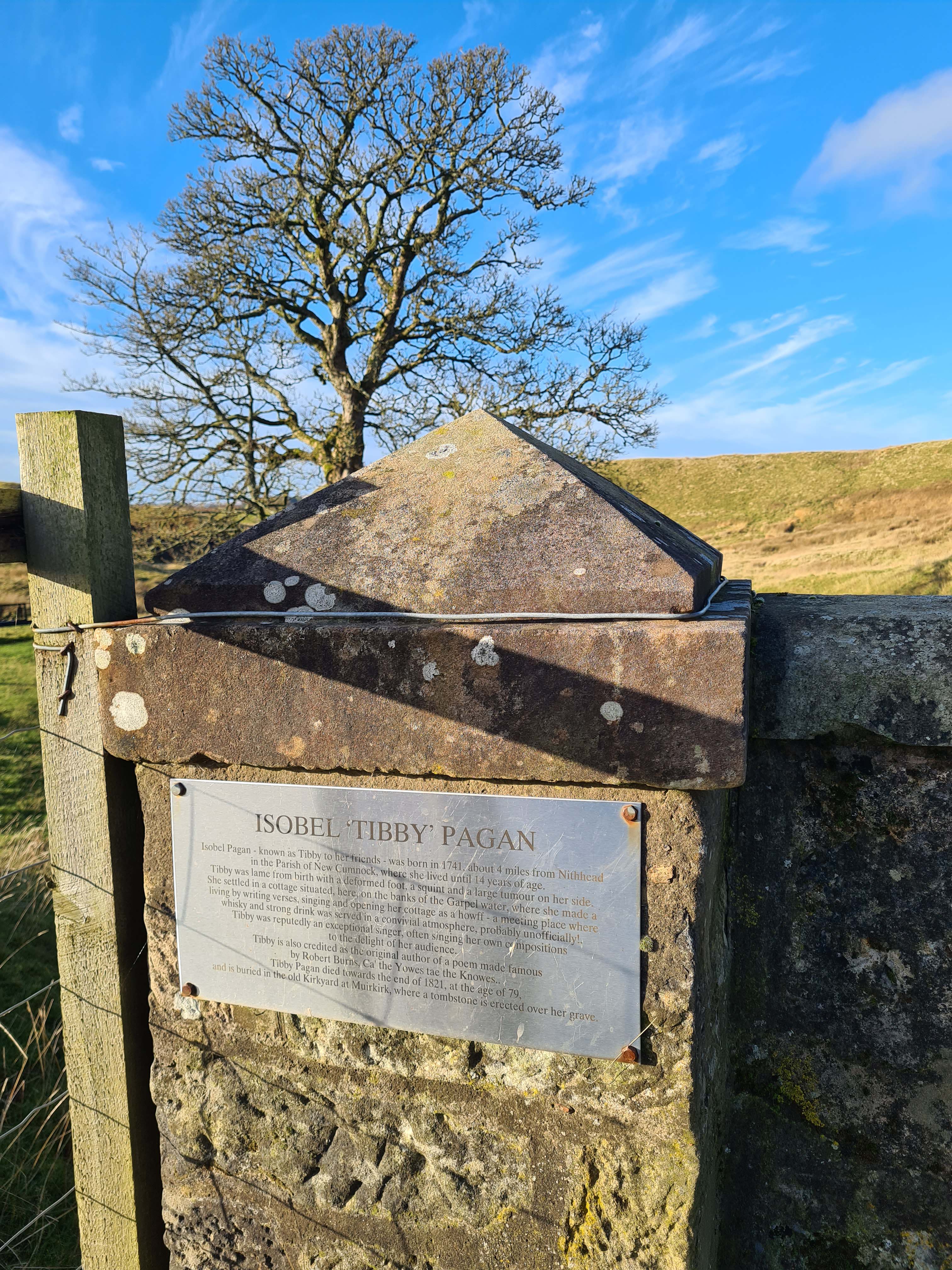 Information plaque mounted on a stone bridge about Tibbie Pagan,