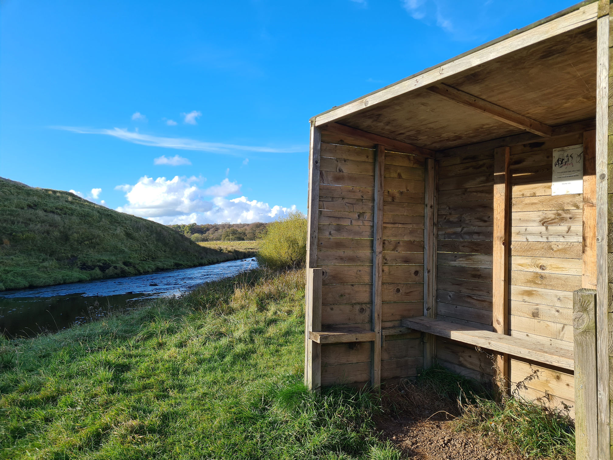 Wooden open hut with a seat built beside the river