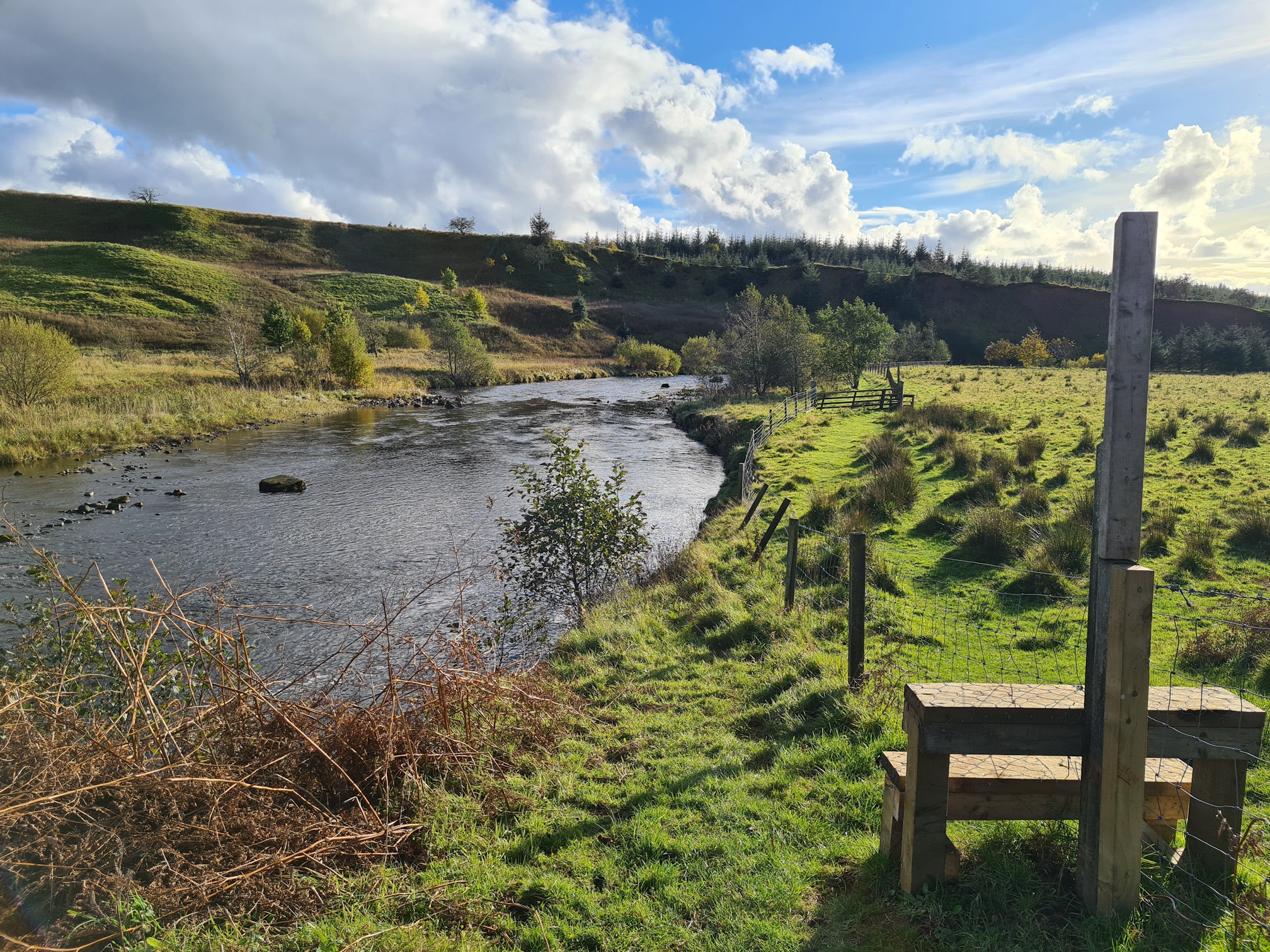 River path ends. A wooden style to step over the wired fence to another grassy path