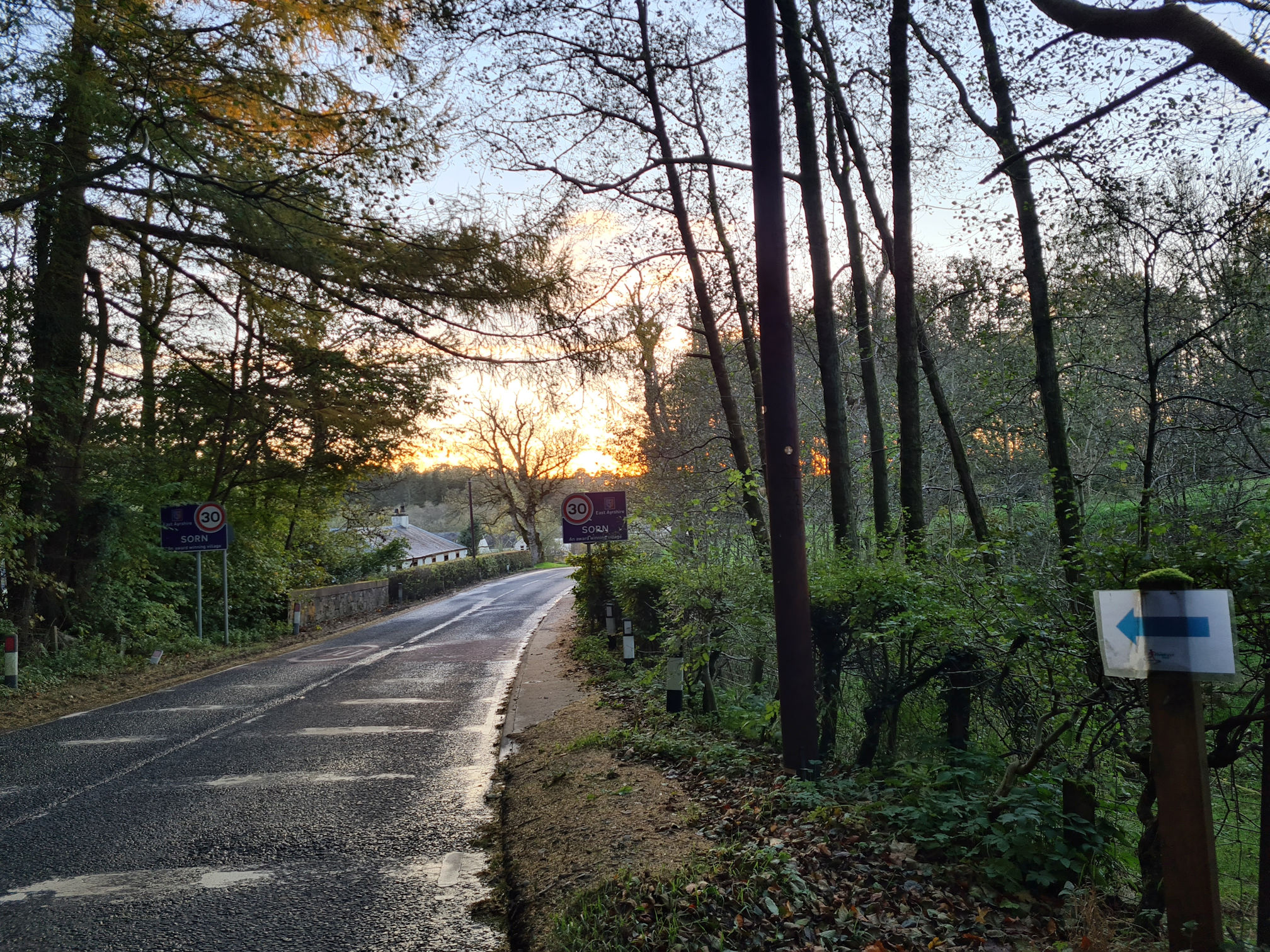 A road through the village of Sorn, the sun is setting creating an orange glow in the sky