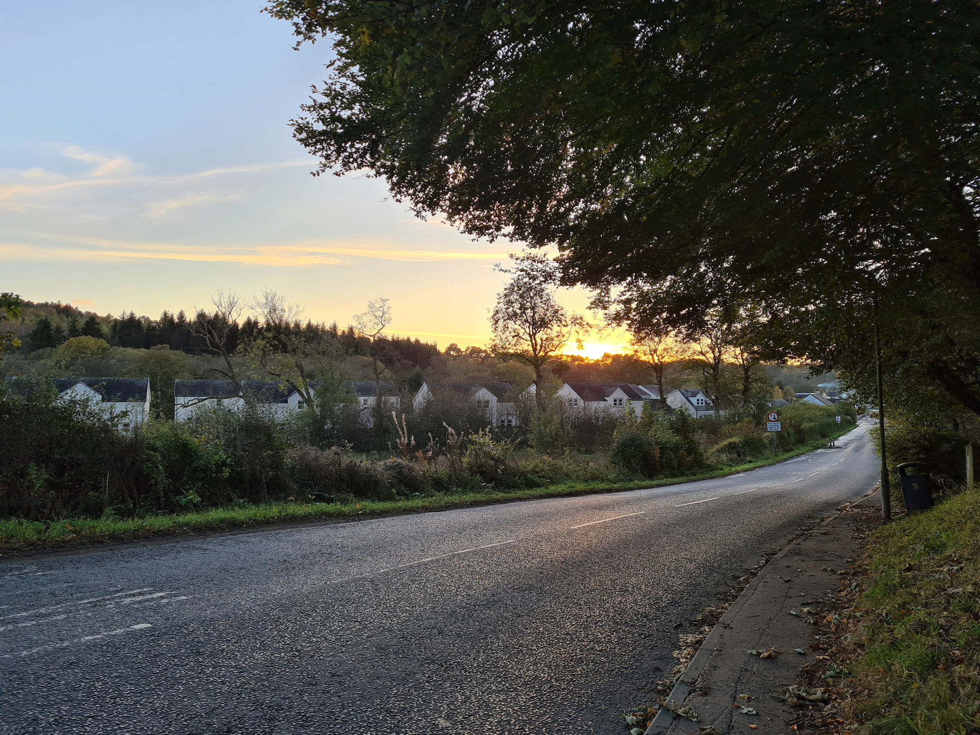 A road through the village of Sorn, the sun is setting creating an orange glow in the sky
