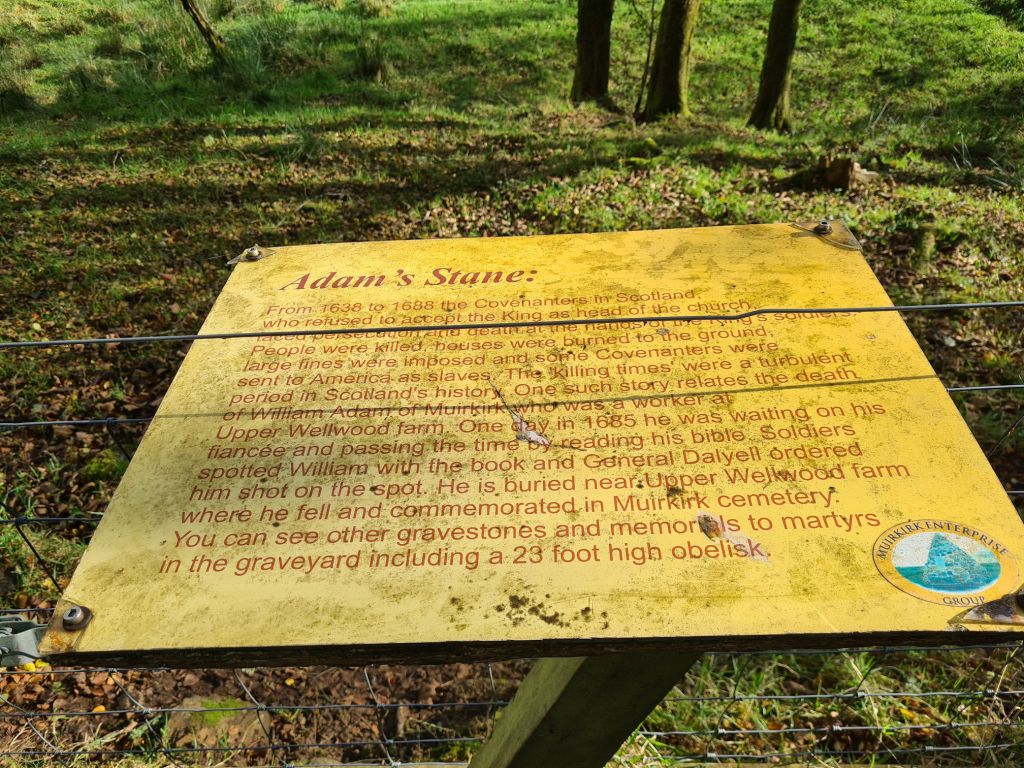 A sign with information about William Adam's grave, a Covenanter who was killed here by government troops