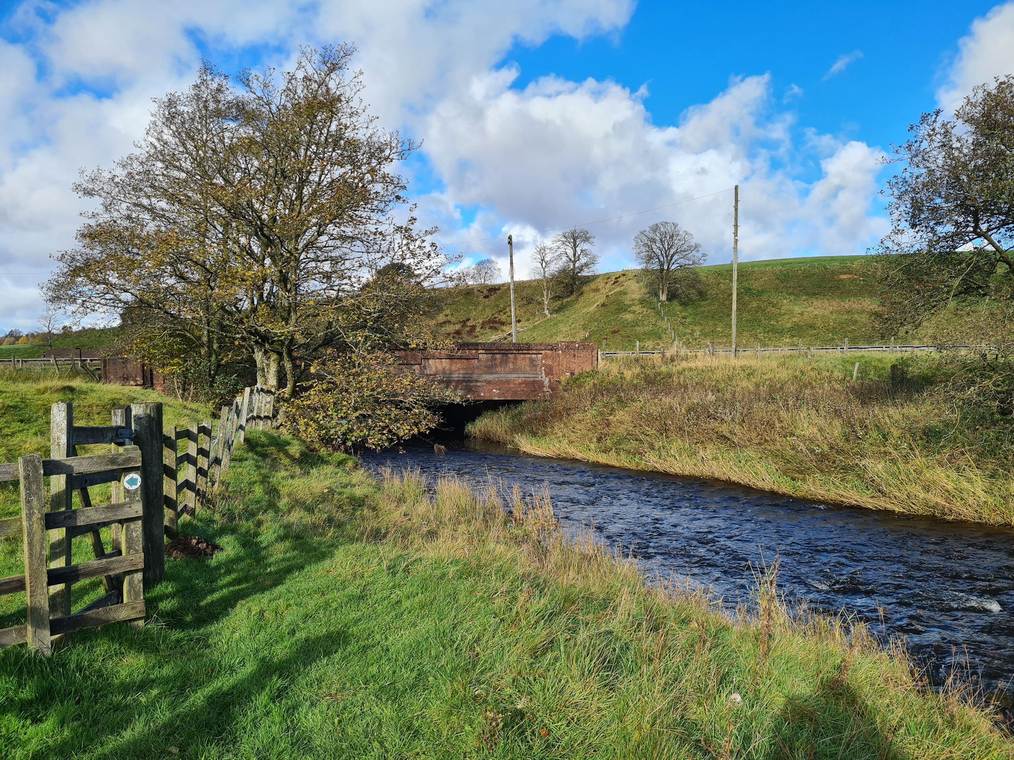 Gate to leave the riverbank, road bridge where the water flows under