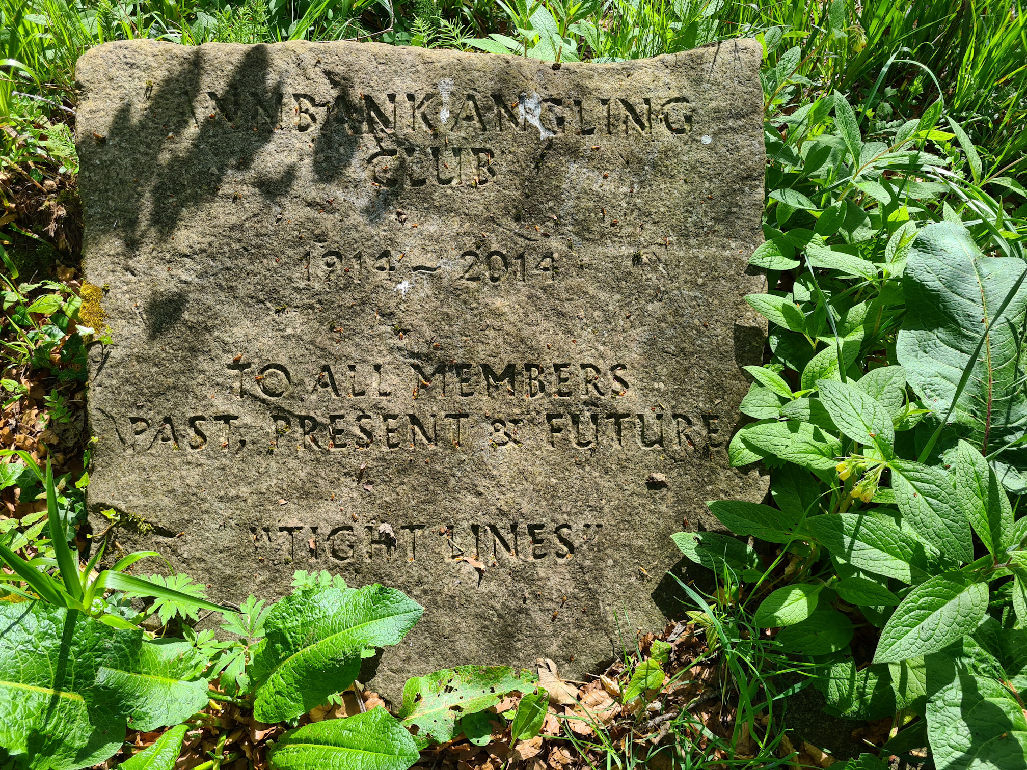 Stone slab inscribed with a dedication to the Annbank Angling Club from 1914 to 2014, to all members past, present and future.