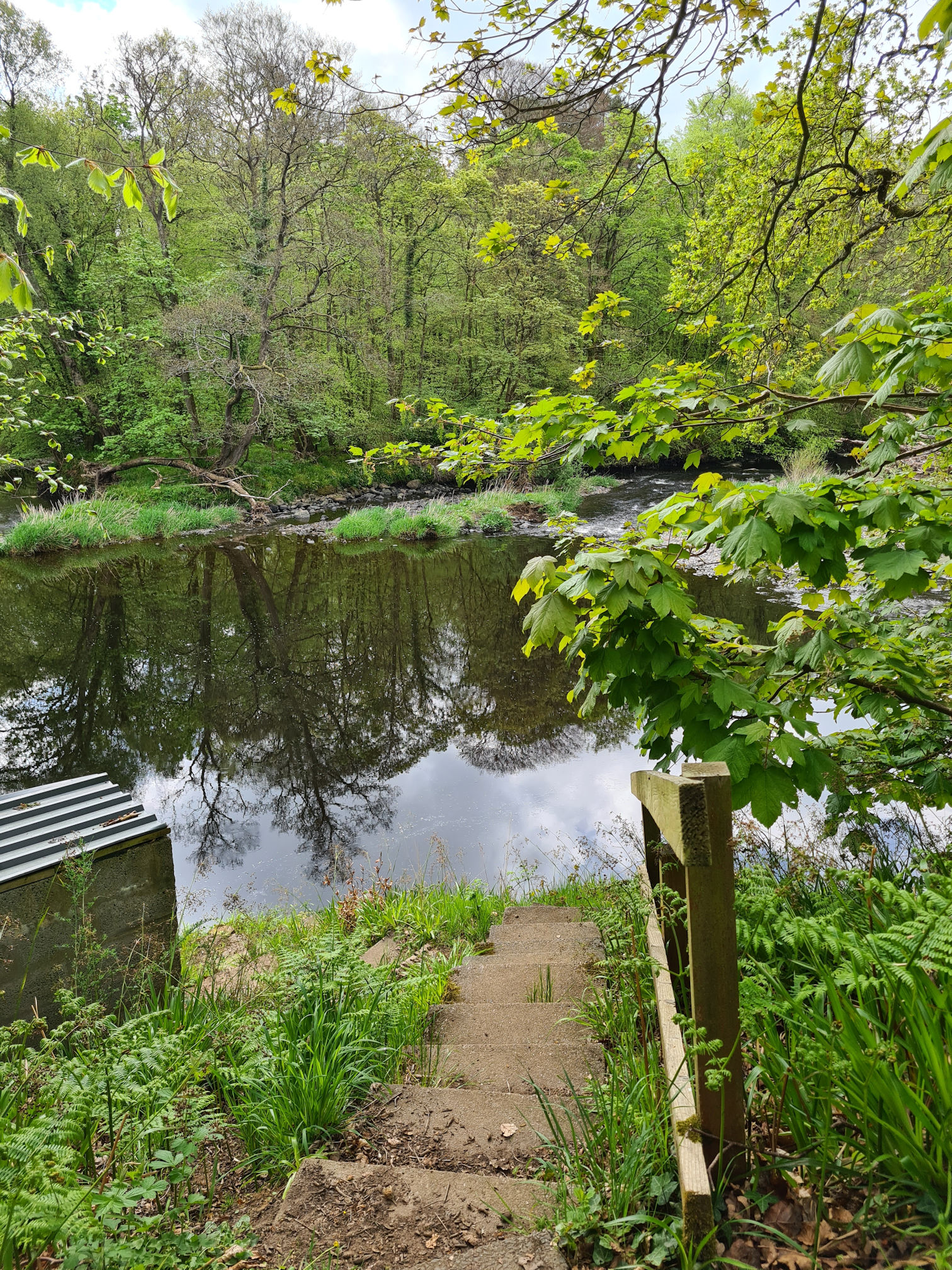 Steep stone steps going down to the river, a concrete hut to the left