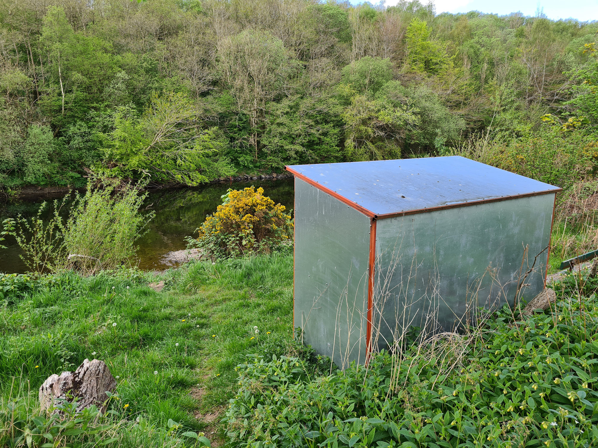 Metal hut sitting beside the river