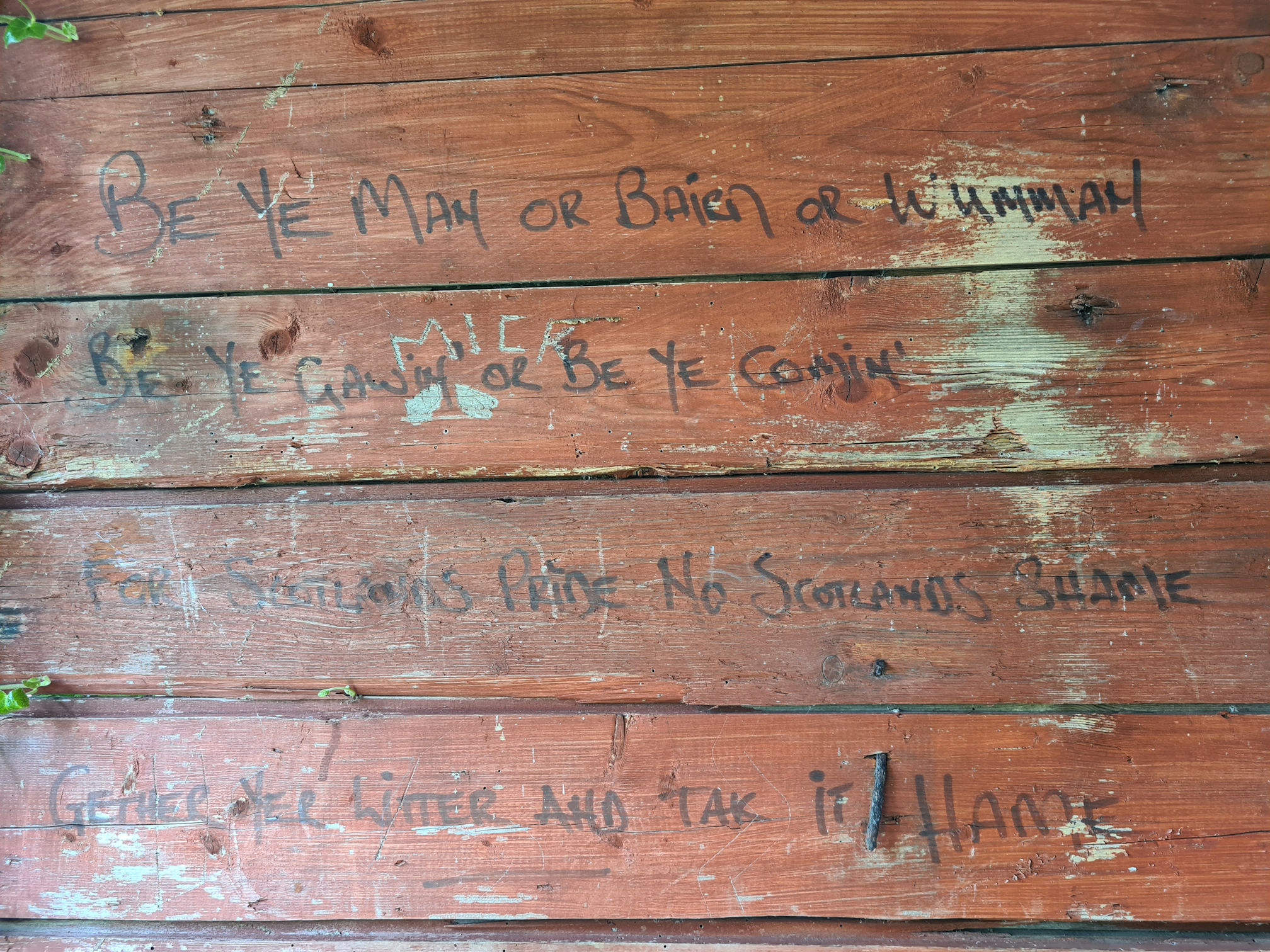The writing on the wooden hut reads:
Be ye man or bairn or wumman
Be ye gawin or be ye comin'
For Scotland's pride, no Scotland's shame
Gether yer litter and tak it hame