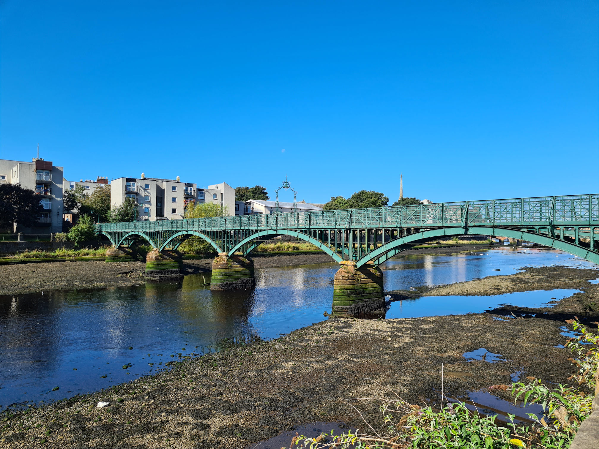 Green iron footbridge across the River Ayr
