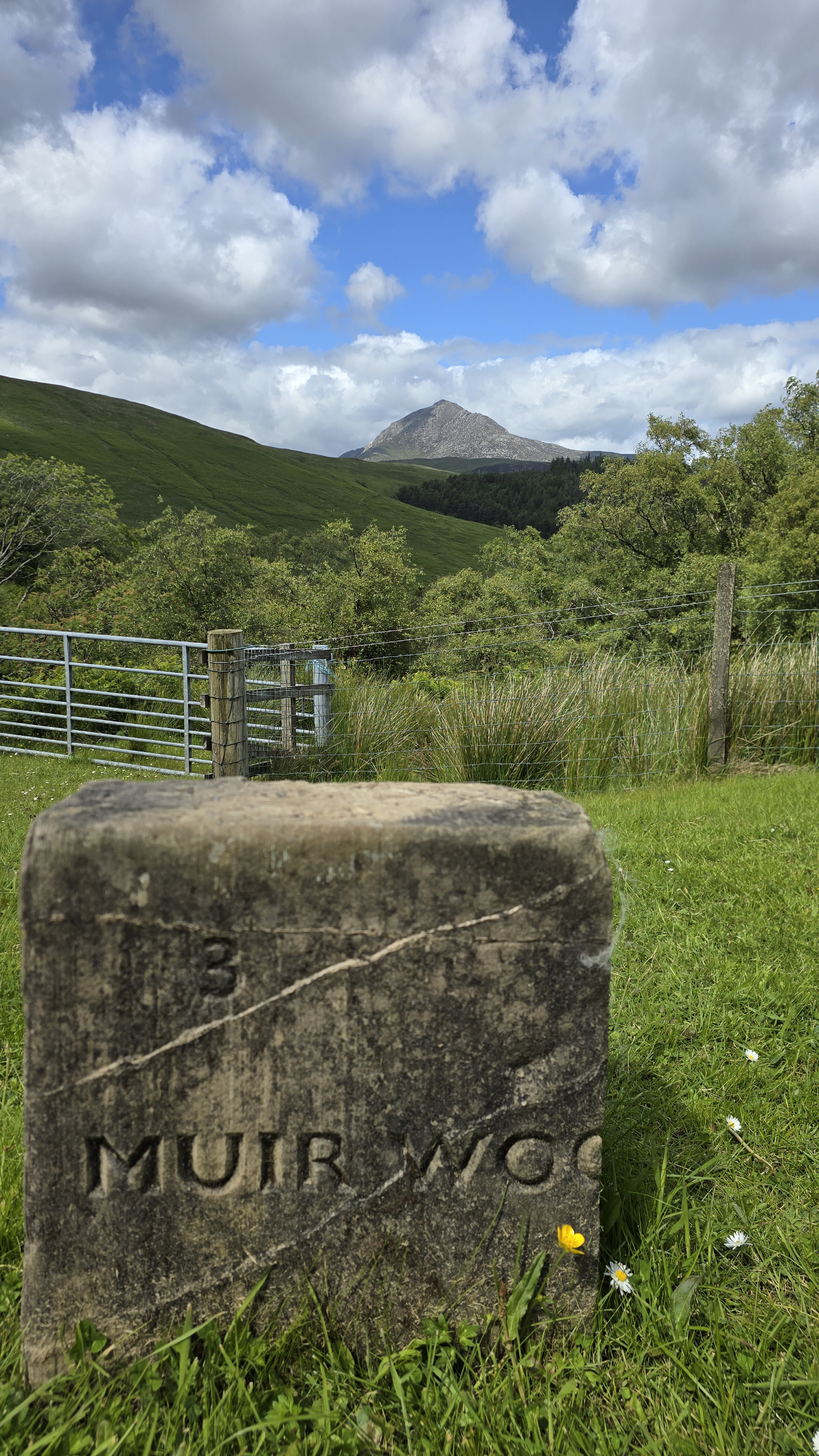 Upright rectangular stone slab with the name "Muir Wood" carved into the stone. This is the name of an artist who photographed this view and many more on the Isle of Arran.