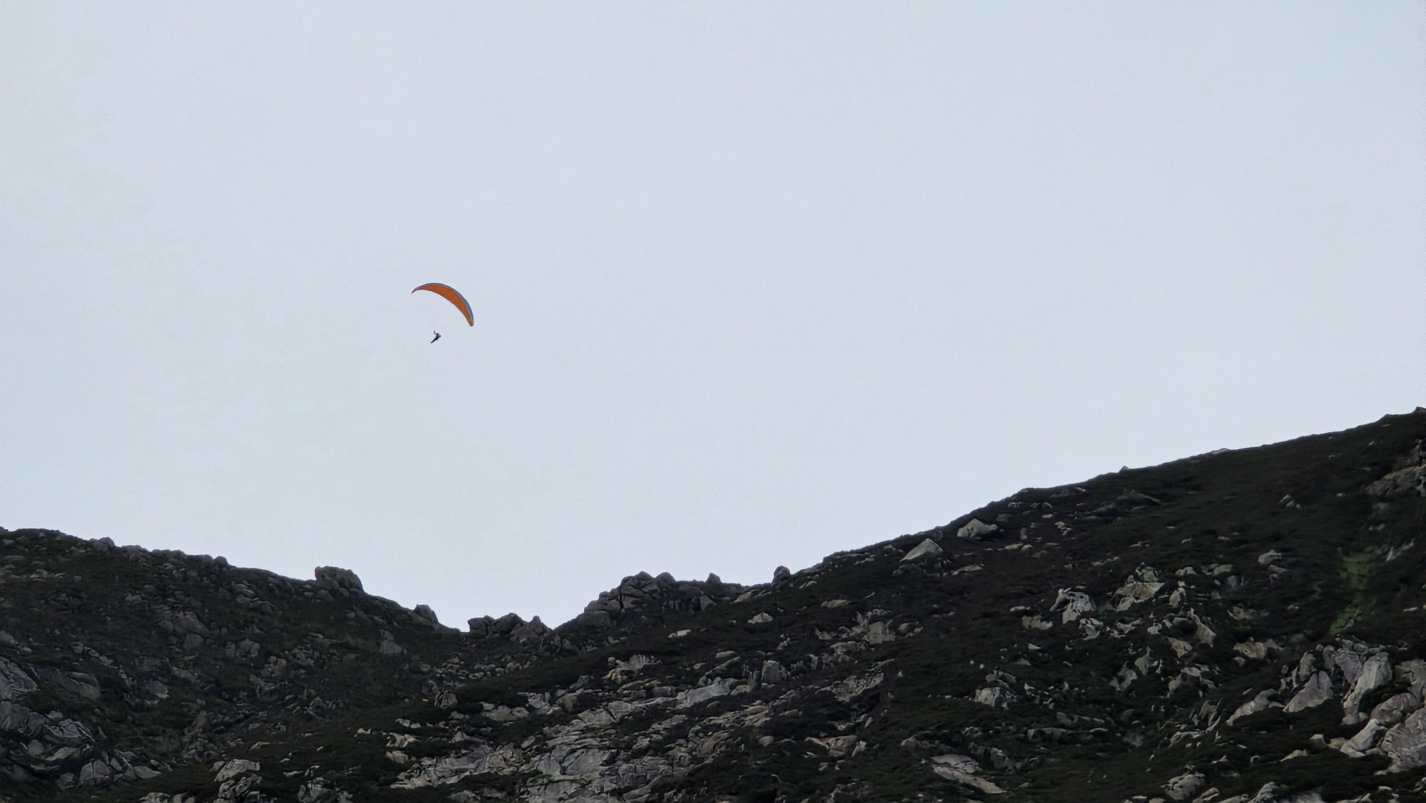 Paraglider flying high above the mountains