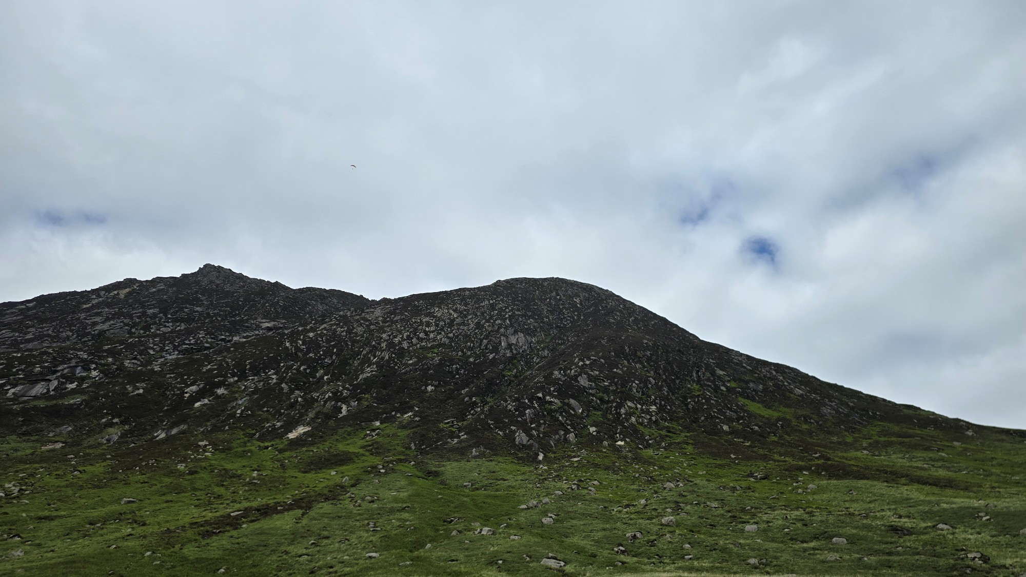 Paraglider flying high above the mountains