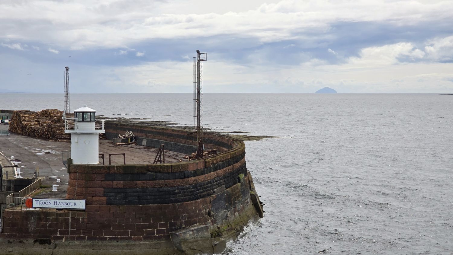 Troon Harbour wall and the island Ailsa Craig in the distance