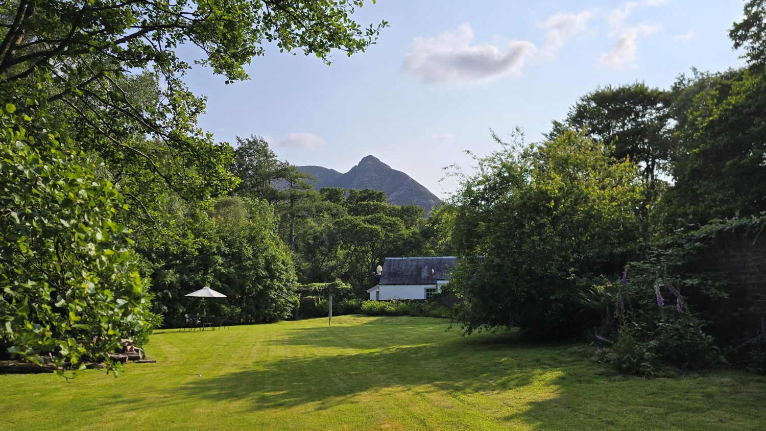 Walled garden, white cottage and mountain peak behind the cottage