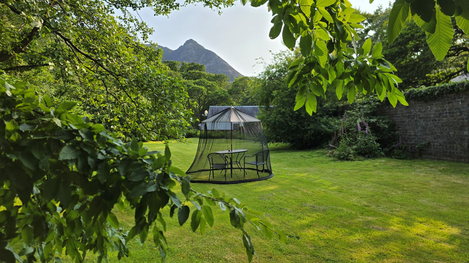 Midge net around parasol, table and chairs in a walled garden