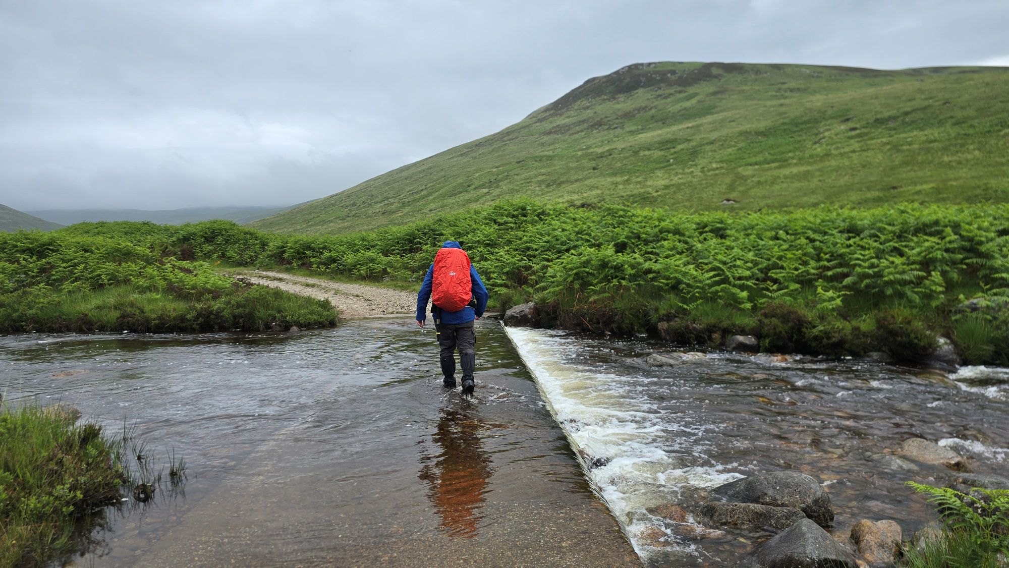 Person walking across a ford on a wet cloudy day